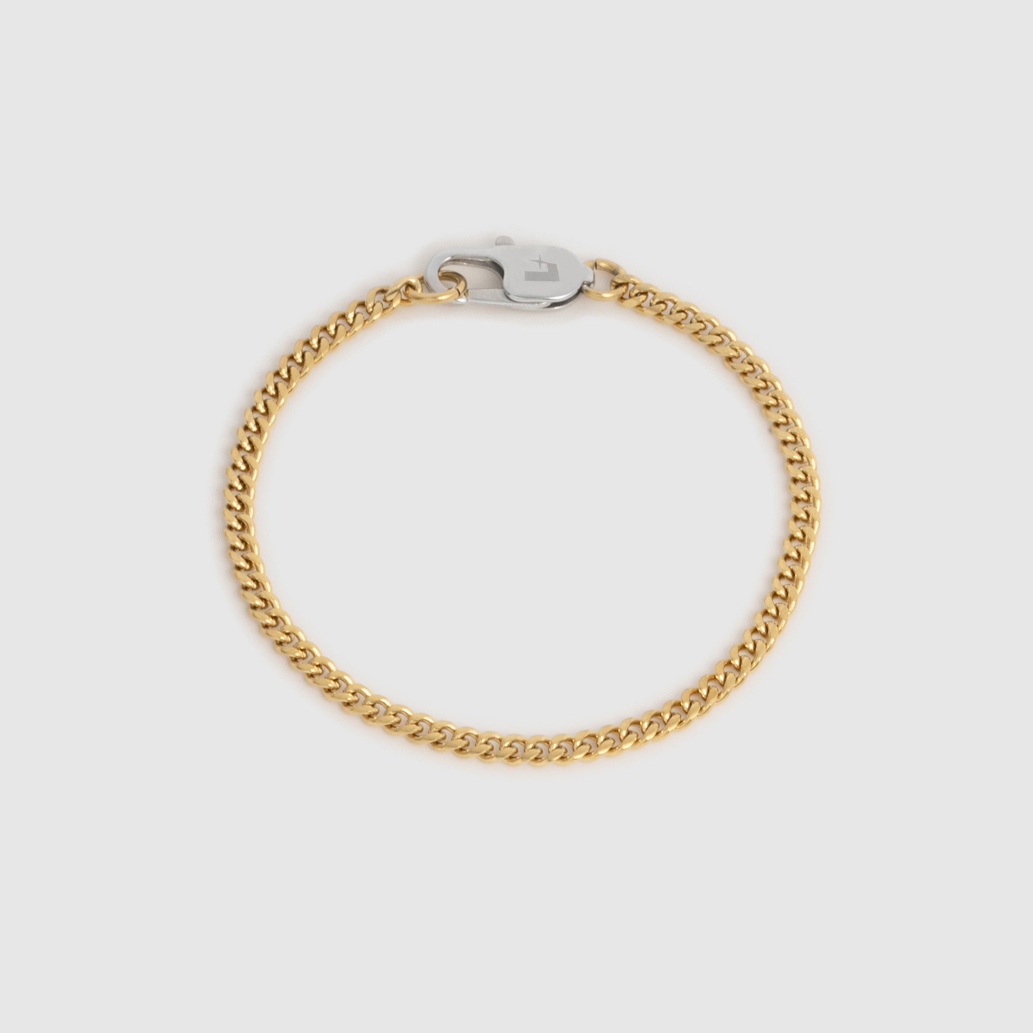 A gold-toned curb chain bracelet with a silver-toned lobster clasp, displayed on a light gray background.