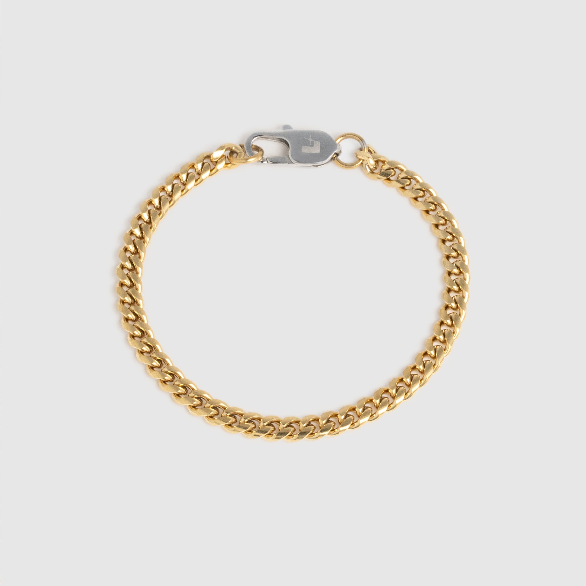 A gold-tone Cuban link chain bracelet with a silver-tone lobster clasp, displayed on a light gray background.