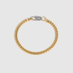 A gold-tone Cuban link chain bracelet with a silver-tone lobster clasp, displayed on a light gray background.