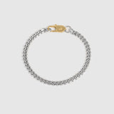 A silver-toned curb chain bracelet with a gold-toned lobster clasp, displayed on a light gray background.