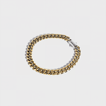 Gold thick chain bracelet with silver clasp on white background
