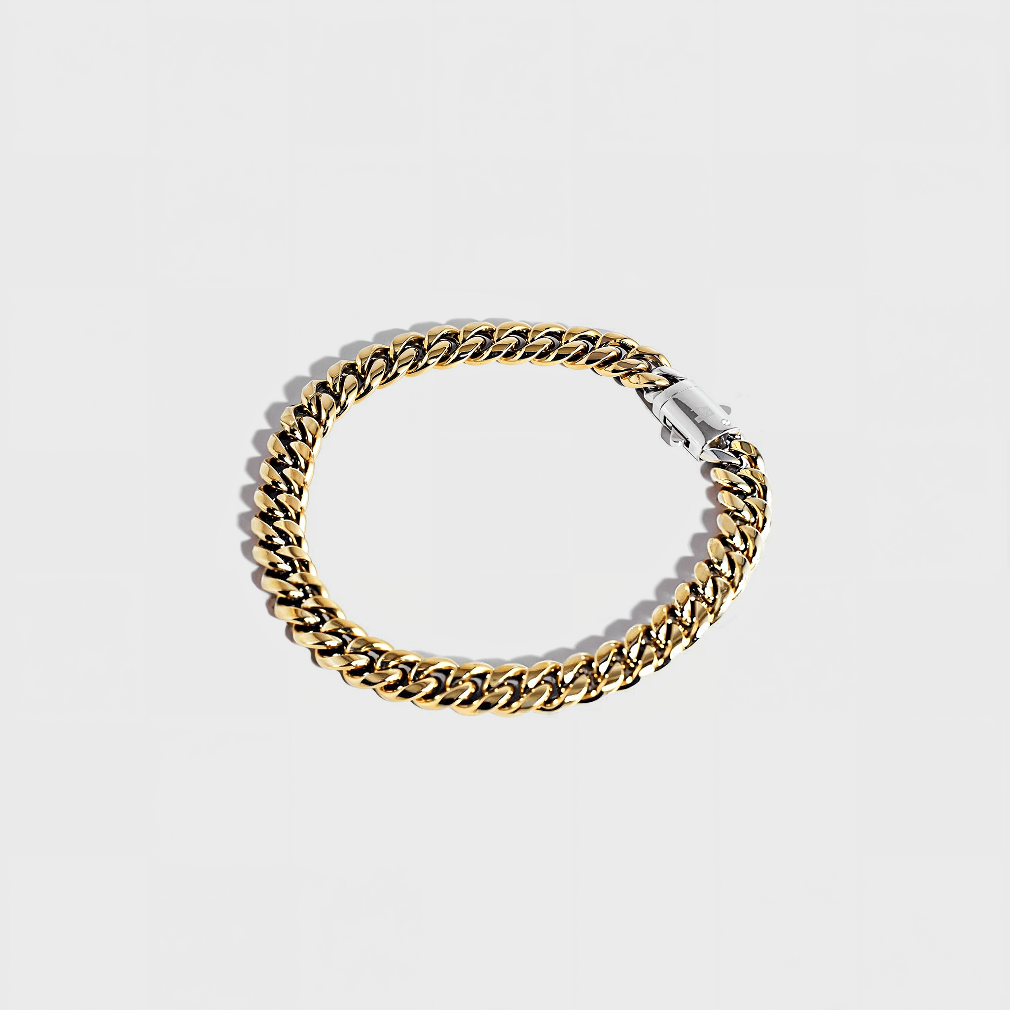 Gold thick chain bracelet with silver clasp on white background
