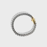 Silver thick chain bracelet with gold clasp on white background