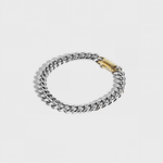 Silver thick chain bracelet with gold clasp on white background