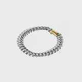 Silver thick chain bracelet with gold clasp on white background