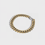 Gold thick chain bracelet with silver clasp on white background