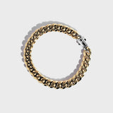 Gold thick chain bracelet with silver clasp on white background