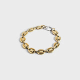 Gold mariner chain bracelet with silver oval clasp on white background
