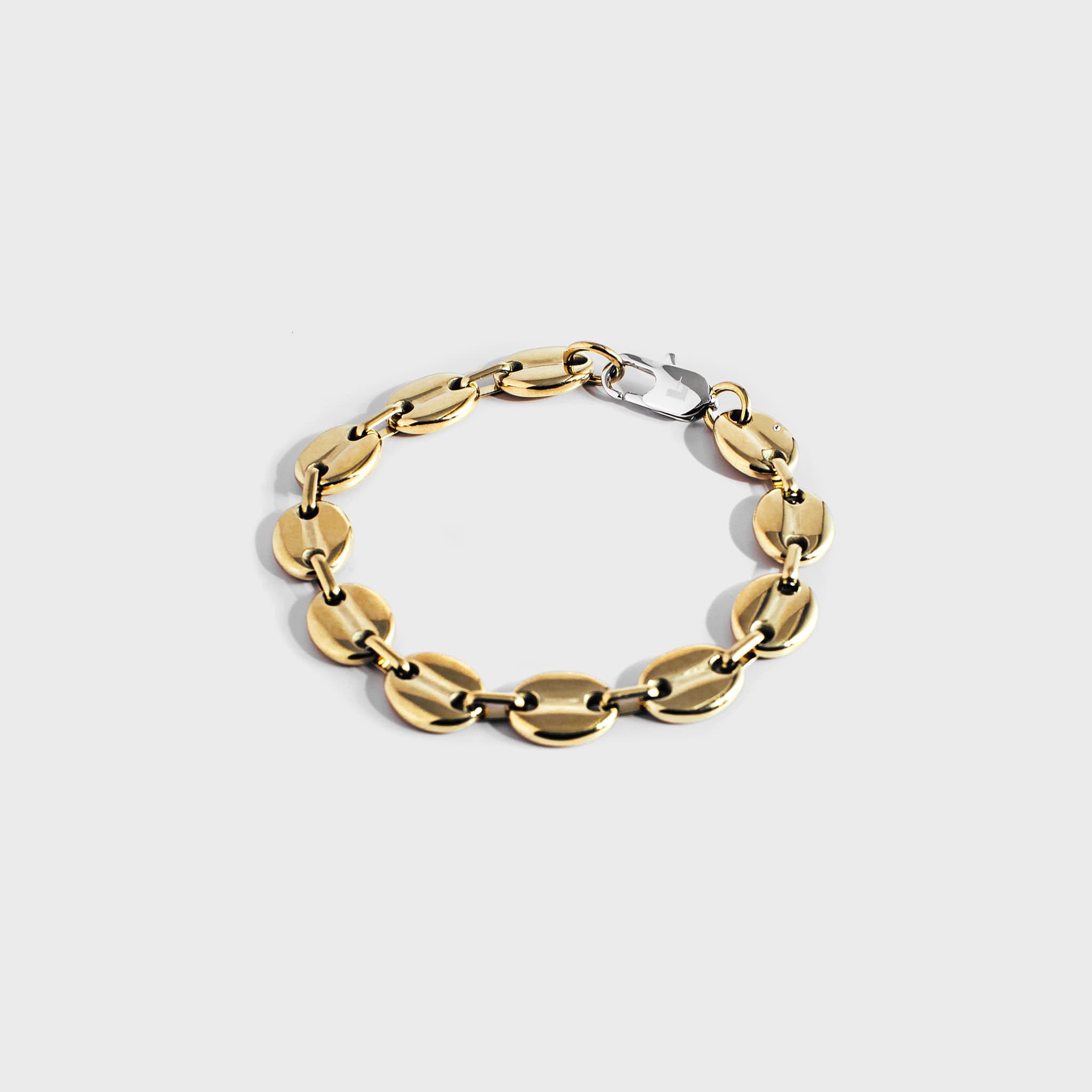 Gold mariner chain bracelet with silver oval clasp on white background
