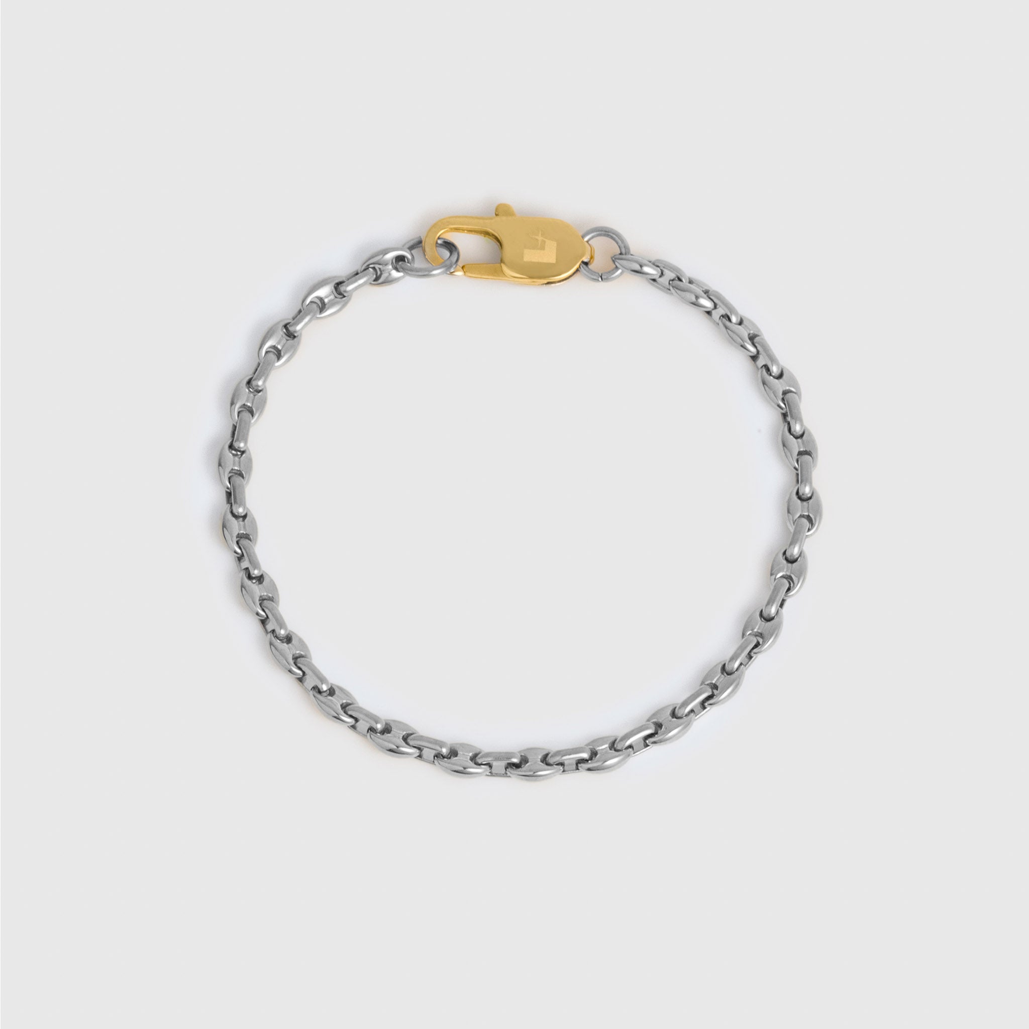 A silver-toned metal chain bracelet with a gold lobster clasp displayed on a light gray background.