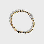 Gold mariner chain bracelet with silver oval clasp on white background
