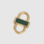 A gold-toned metal lock accessory with a dark green rectangular enamel inlay, shown on a light gray background.