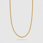 A gold chain necklace with a classic curb link design, shown hanging against a light gray background.