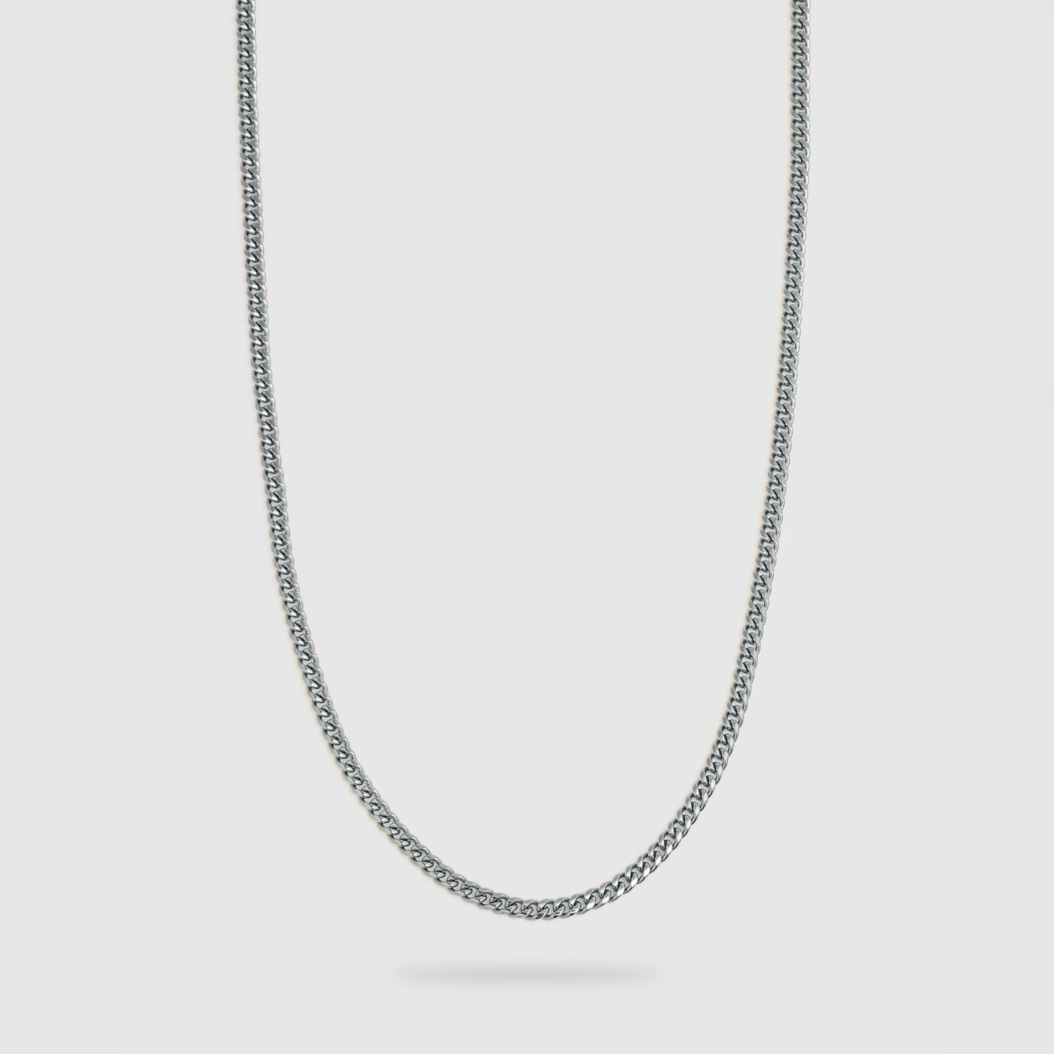A silver-toned metal chain necklace with a classic curb link design, shown against a light gray background.