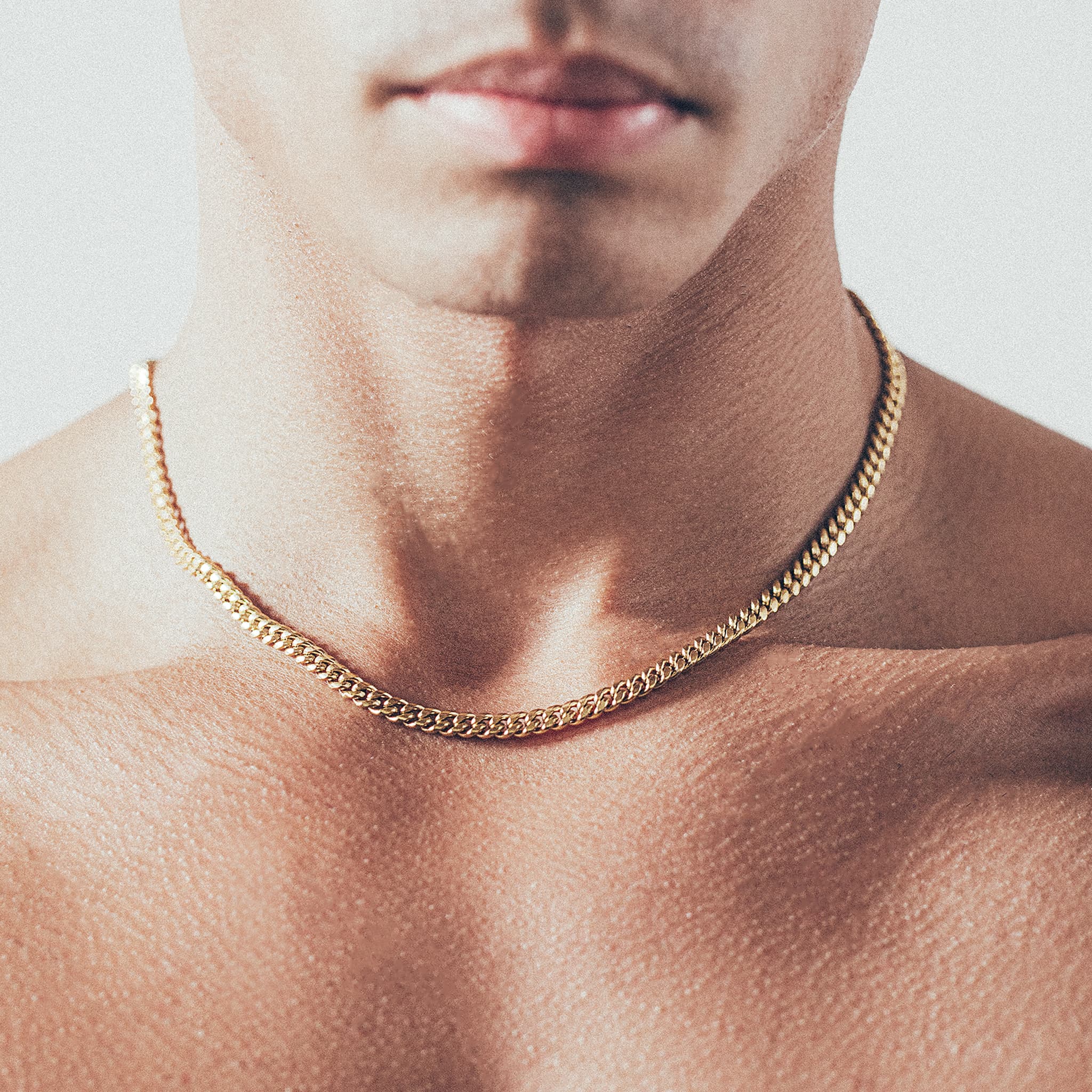 Close-up of man wearing gold Cuban chain necklace