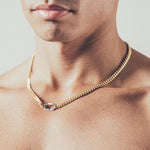 Close-up of man wearing  gold Cuban chain necklace with silver carabiner clasp
