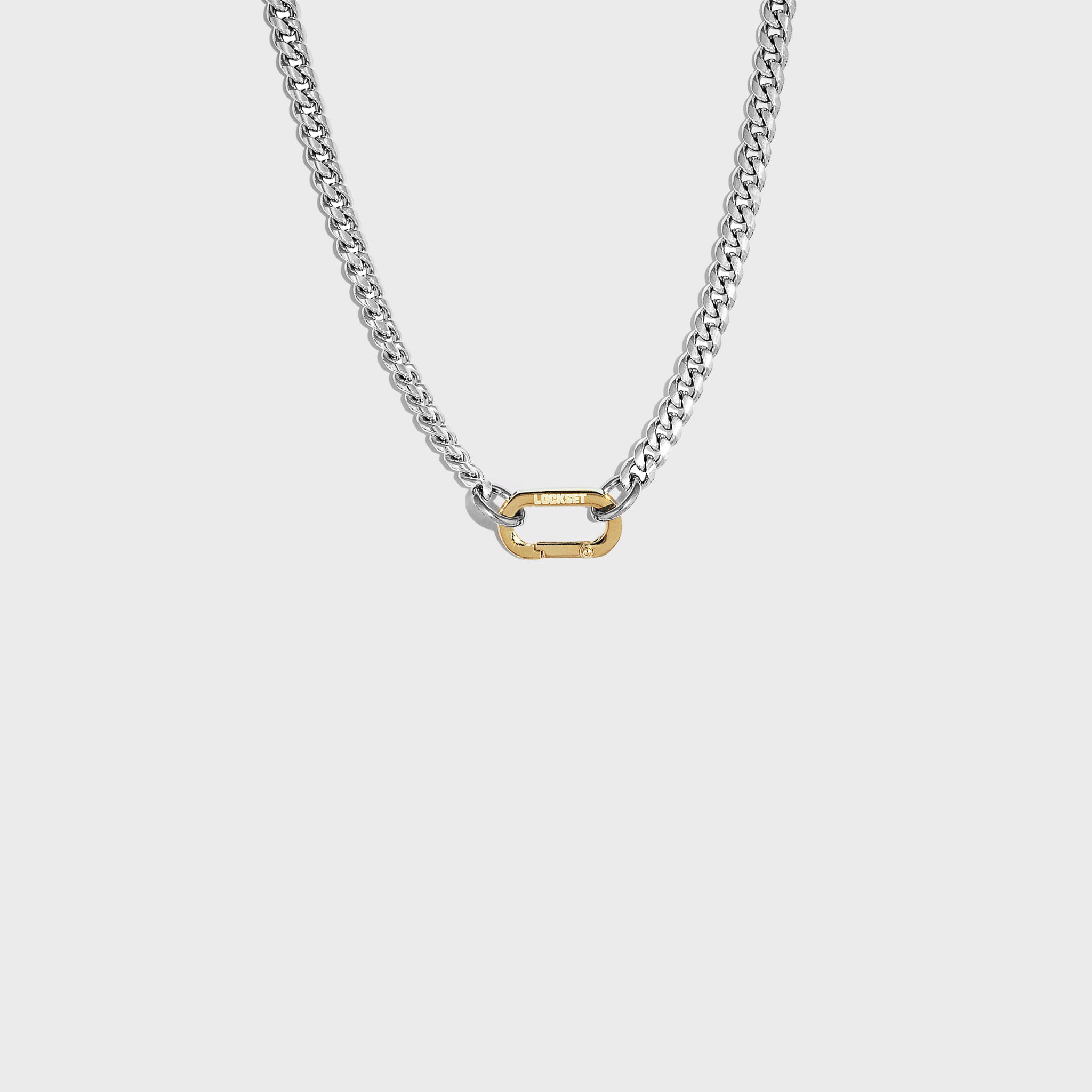 Silver cuban chain with gold carabiner clasp on white background