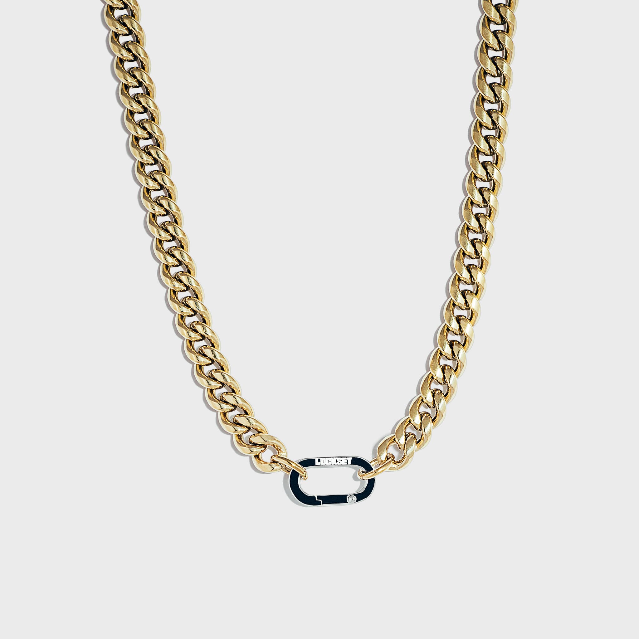 Thick gold Cuban chain on white background with silver carabiner clasp