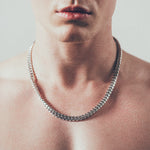 Close-up of man wearing thick silver Cuban chain necklace