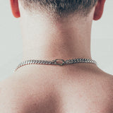 Close-up of man wearing thick silver Cuban chain necklace