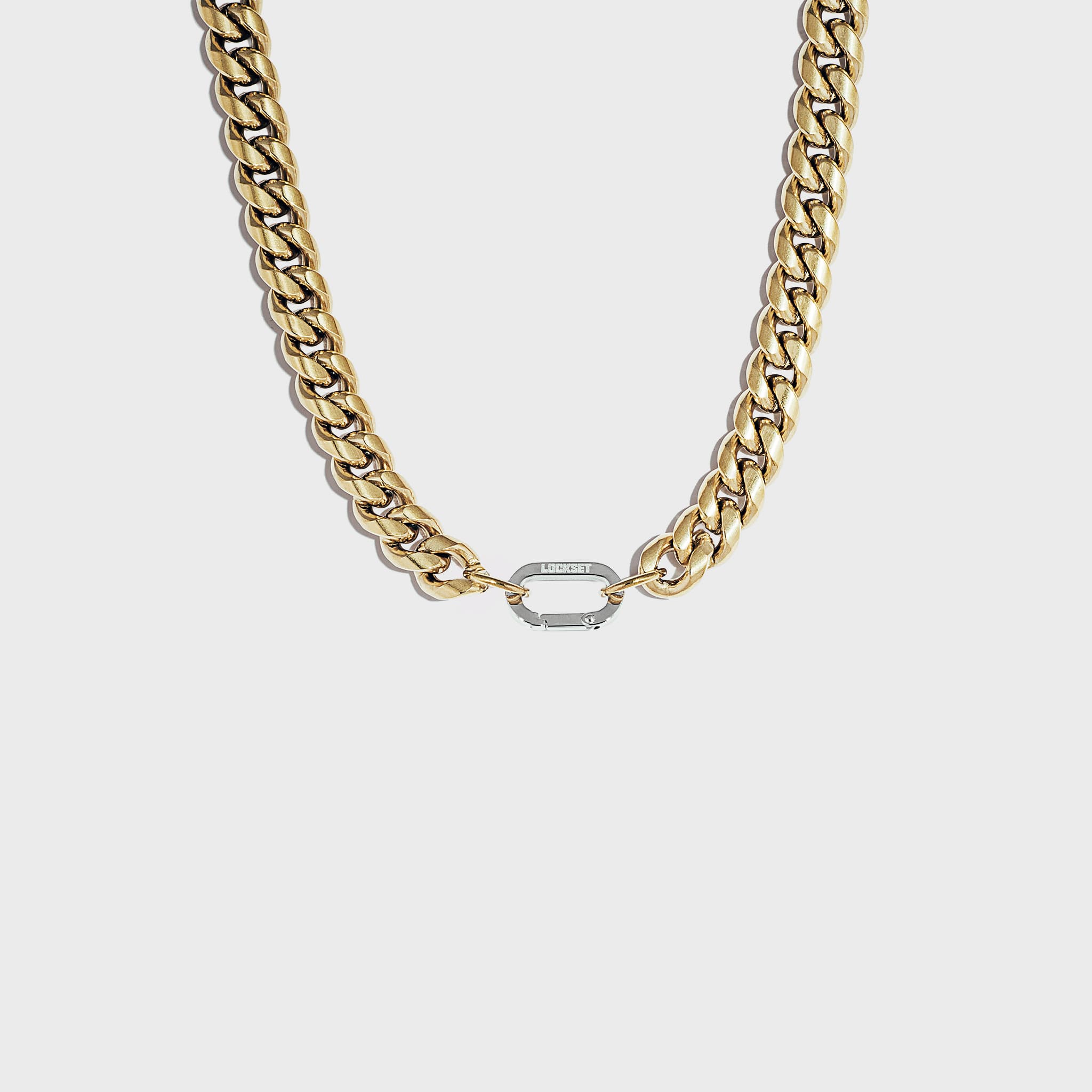 Thick gold cuban chain on white background with silver carabiner clasp