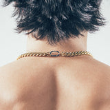 Close-up of man wearing thick gold Cuban chain necklace with silver carabiner clasp