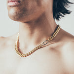 Close-up of man wearing thick gold Cuban chain necklace with silver carabiner clasp