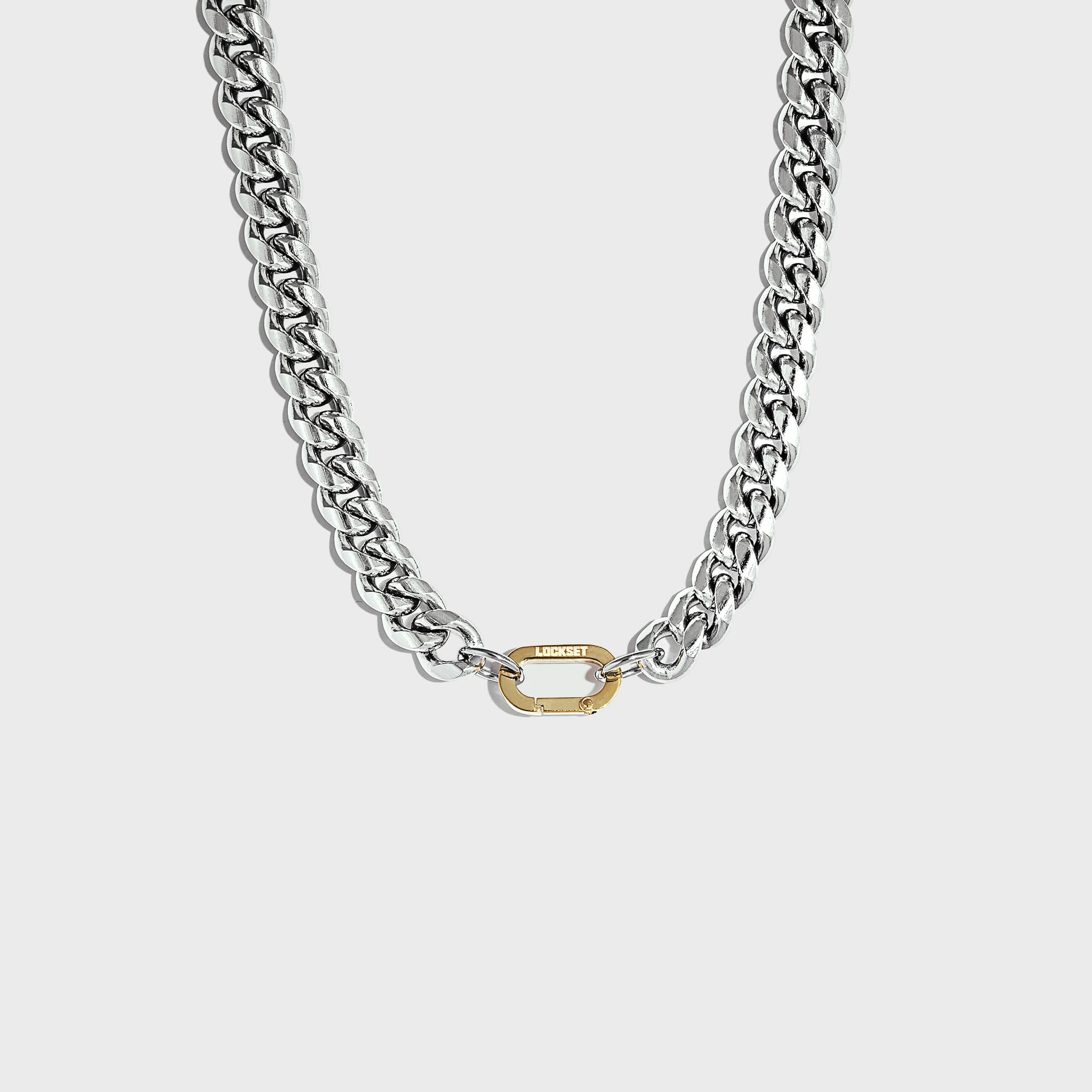Thick silver cuban chain with gold carabiner clasp on white background
