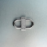 Silver double lock pendant featuring centered diamond detail on gray background