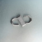 Silver double open-lock pendant featuring centered diamond detail on gray background