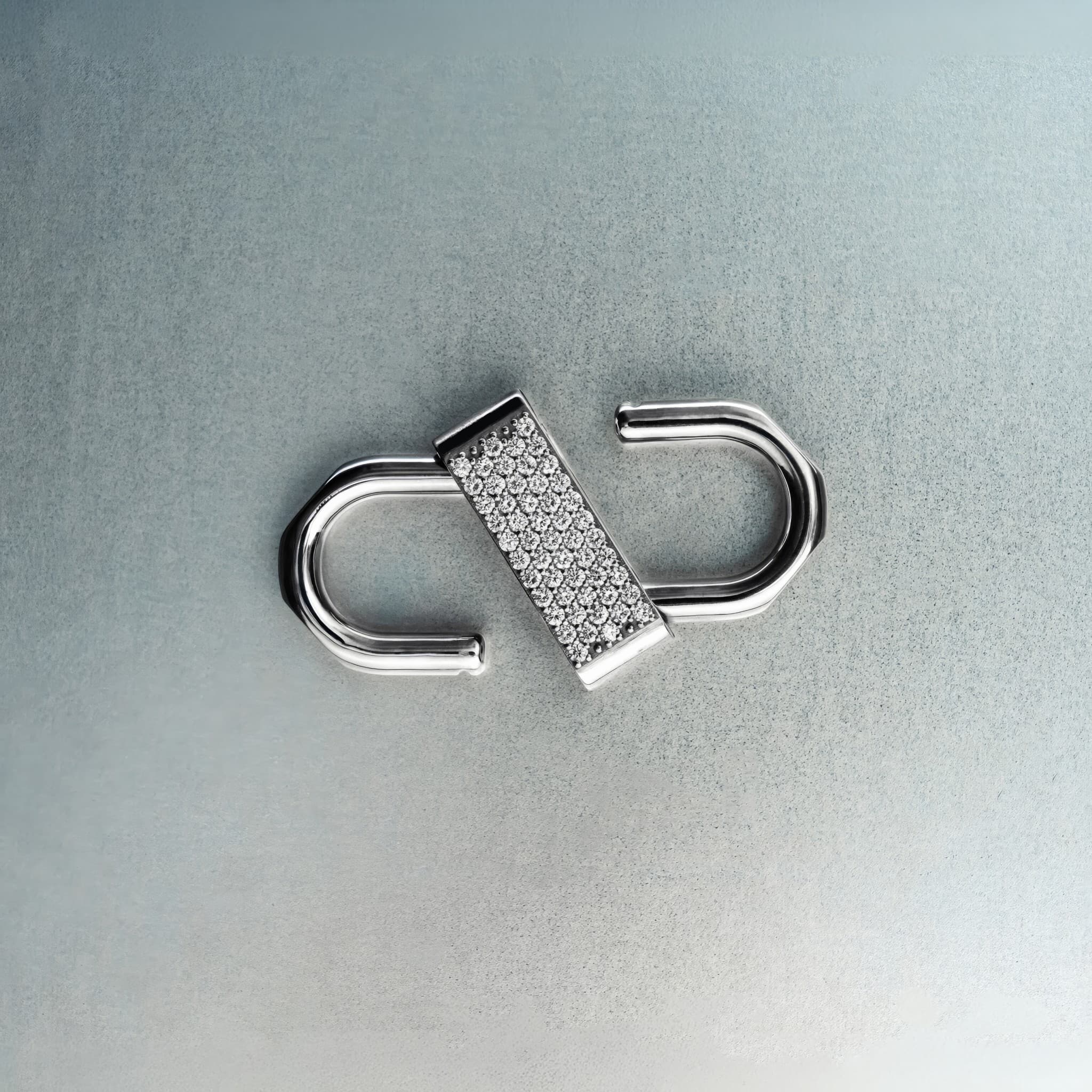 Silver double open-lock pendant featuring centered diamond detail on gray background