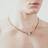 Close-up of man wearing gold chain necklace with silver double-lock pendant featuring centered diamond detail