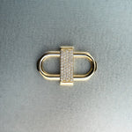 Gold double lock pendant featuring centered diamond detail on gray background