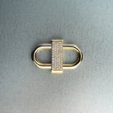 Gold double lock pendant featuring centered diamond detail on gray background
