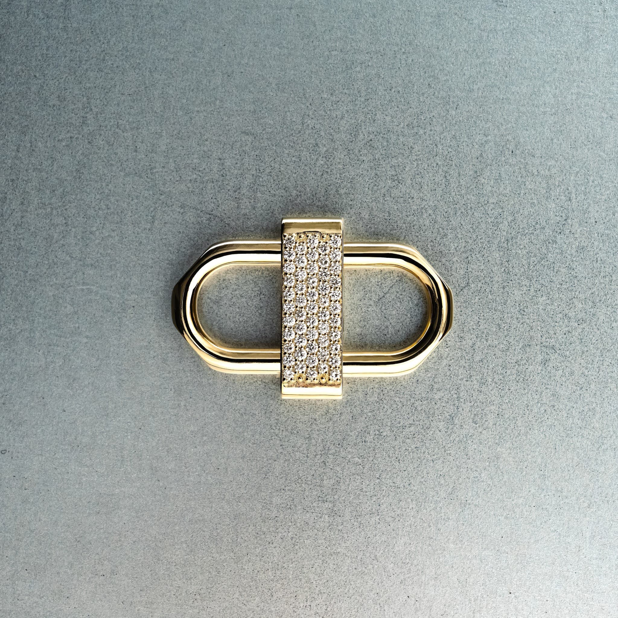 Gold double lock pendant featuring centered diamond detail on gray background