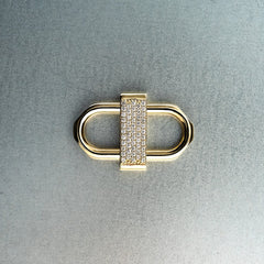 Gold double lock pendant featuring centered diamond detail on gray background