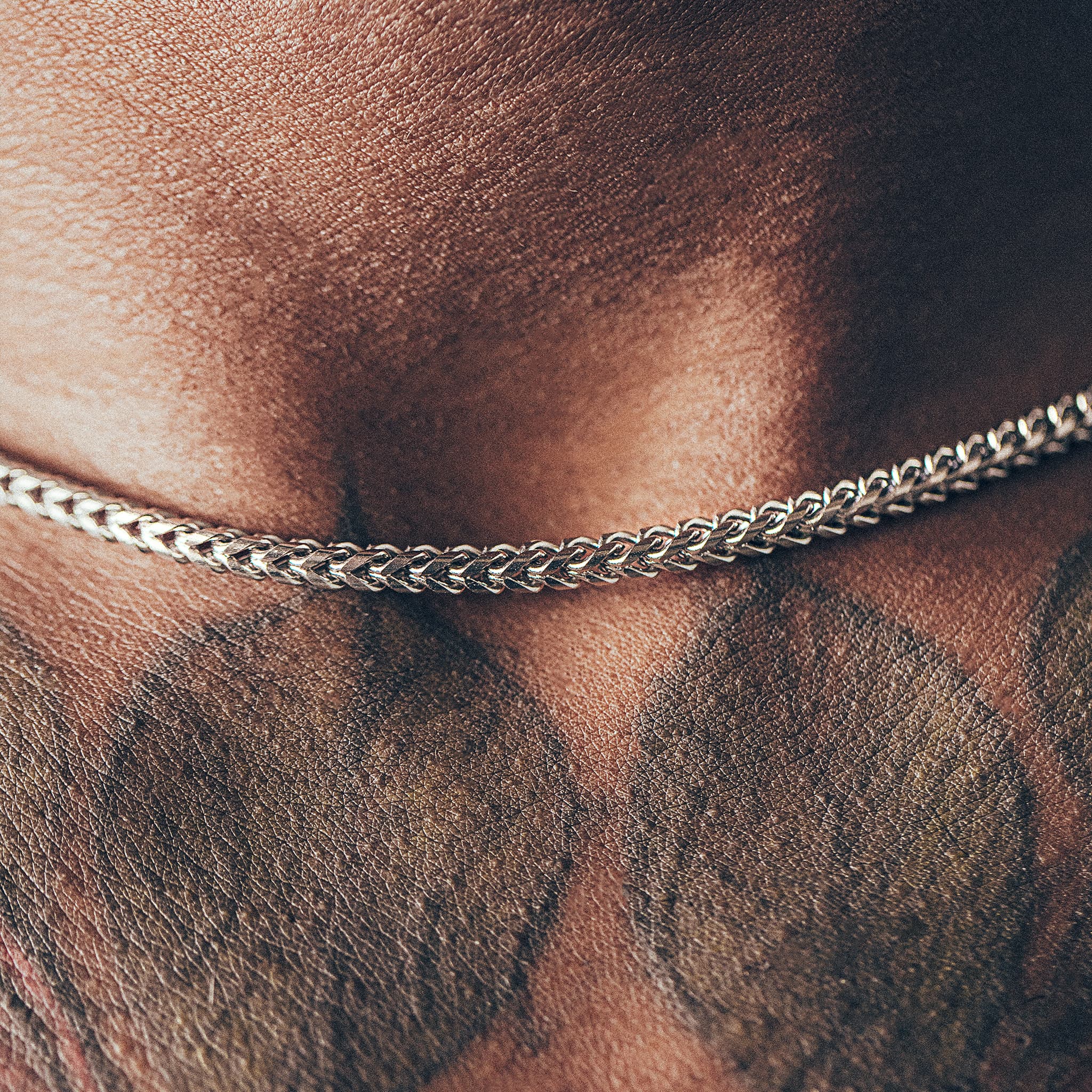 Close up of man wearing silver chain necklace