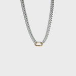 Thick silver chain necklace with gold carabiner clasp on white background