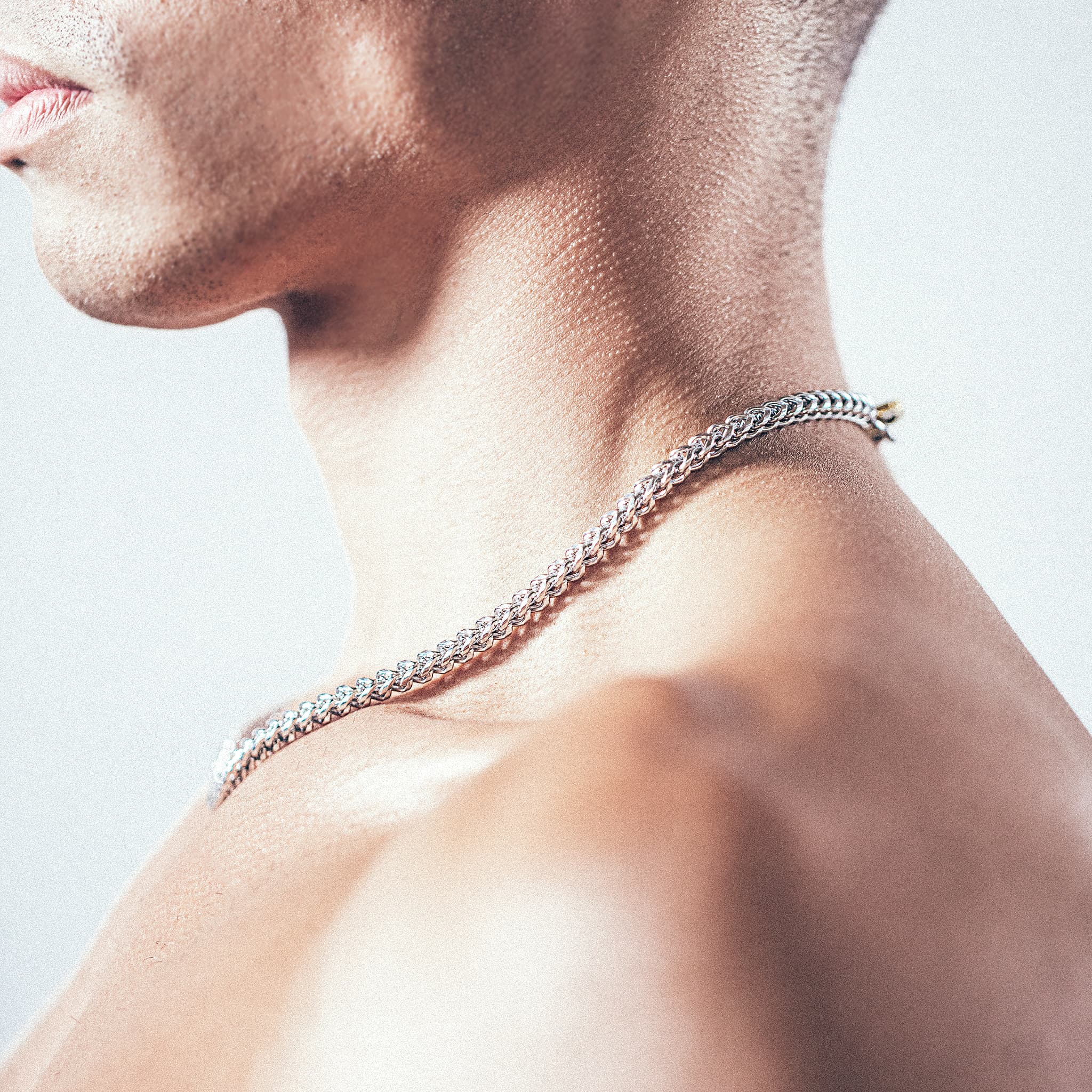 Close-up of man wearing silver chain necklace 