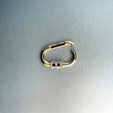 Open gold carabiner pendant featuring diamond lock detail on light gray background