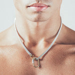 Close-up of man wearing silver chain necklace with gold carabiner lock pendant and gold carabiner clasp