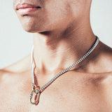 Close-up of man wearing silver chain necklace with gold carabiner lock pendant and gold carabiner clasp