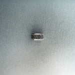 Silver hex nut bead featuring black diamond detailing on light gray background