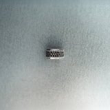 Silver hex nut bead featuring black diamond detailing on light gray background