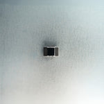 Silver hex nut bead with black diamond detailing on light gray surface