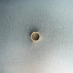 Gold hex nut bead with diamond detailing on light gray surface