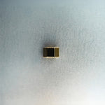 Gold hex nut bead with diamond detailing on light gray surface