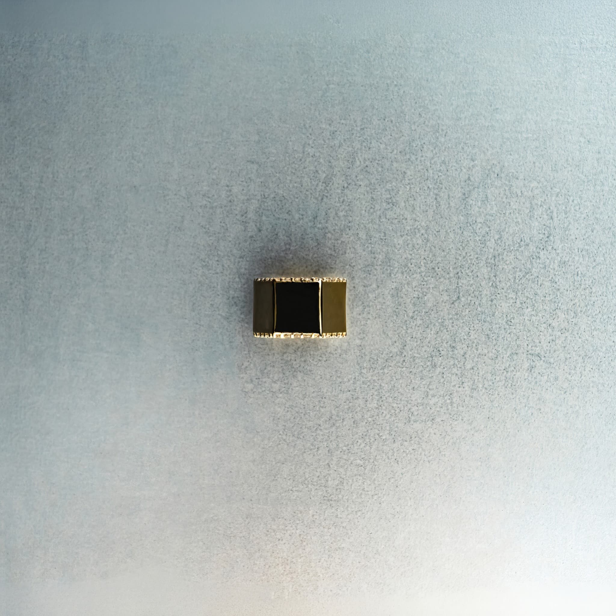 Gold hex nut bead with diamond detailing on light gray surface