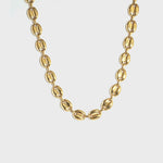 Gold mariner-link chain on white background