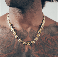 Close-up of man wearing gold mariner chain necklace